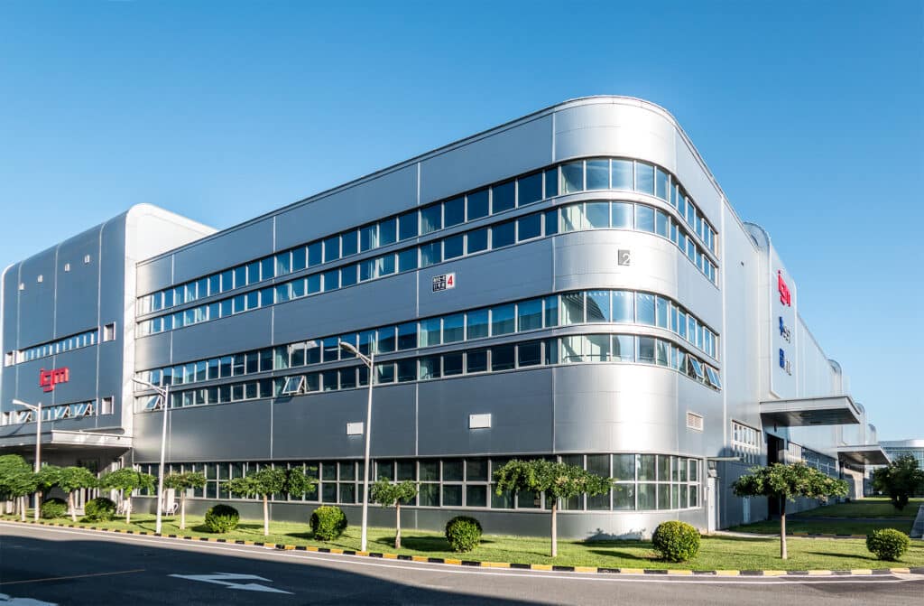 Large silver building with horizontal window layout and logo of IGM on both sides.