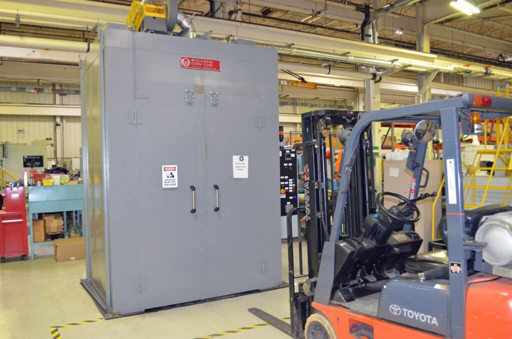 Pre and Post Heat Treat Oven in factory with fork truck parked in front of it.